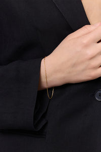 Kvinde i sort blazer med et paperclip type armbånd fra Carré i guldbelagt sterling sølv til mænd og kvinder