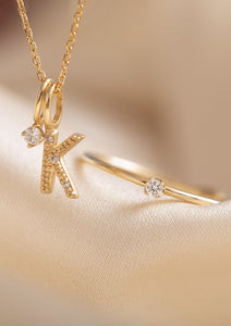 Smykker i 9 og 10 karat ægte guld fra Carré - Bogstavsvedhæng med K sat med diamanter, et vedhæng med diamant og en diamantring - diamant er aprils fødselssten