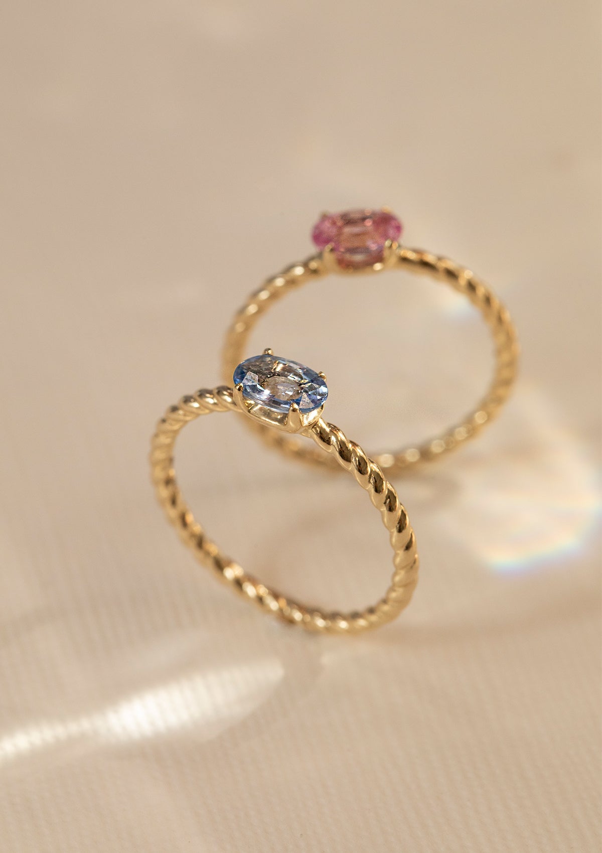 To ringe i 10-karat guld sat med en blå safir og en lyserød safir. Safien er september måneds fødselssten