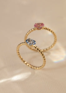 To ringe i 10-karat guld sat med en blå safir og en lyserød safir. Safien er september måneds fødselssten