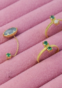 to ringe og en dobbelt ørestik med ædelsten i 18k guld. Alle er sat med smaragd