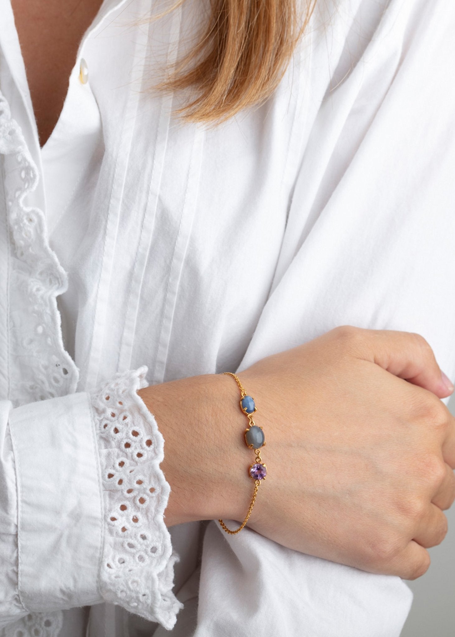 kvinde med armbånd med blandede ædelsten i guld på en tynd guld kæde på udsalg hos carré jewellery