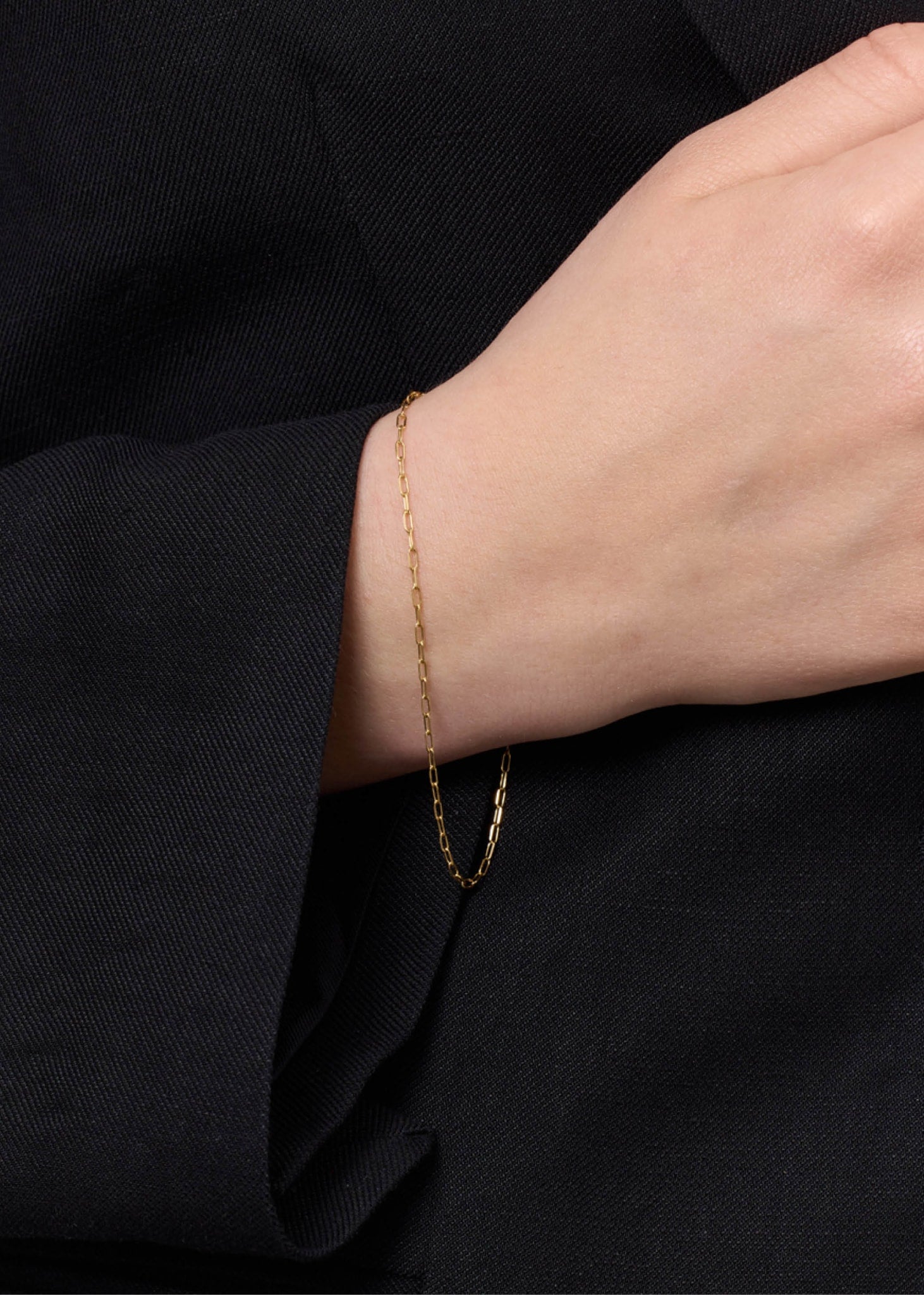 Kvinde med tyndt armbånd i guld fra carré jewellery i figaro vikling til mænd og kvinder