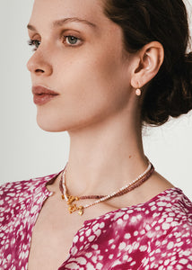 Kvinde med elegante øreringe med kroge i 10 karat ægte guld med en pink opal ædelsten i cabochonslibning 