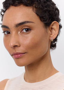 Kvinde med smukke gem hoops fra carré jewellery med tre facetslebne gul-grønne lemon kvarts ædelsten i guld