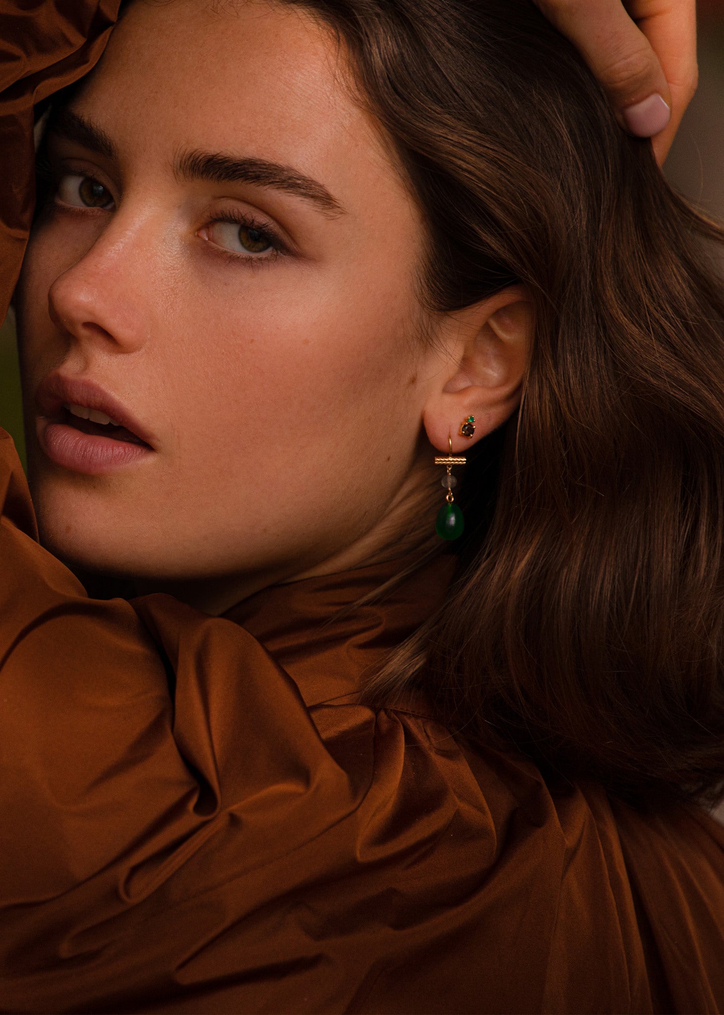 Kvinde med lange hængeøreringe med grøn agat ædelsten og labaradorit ædelsten i guldbelagt sterling sølv fra carré jewellery
