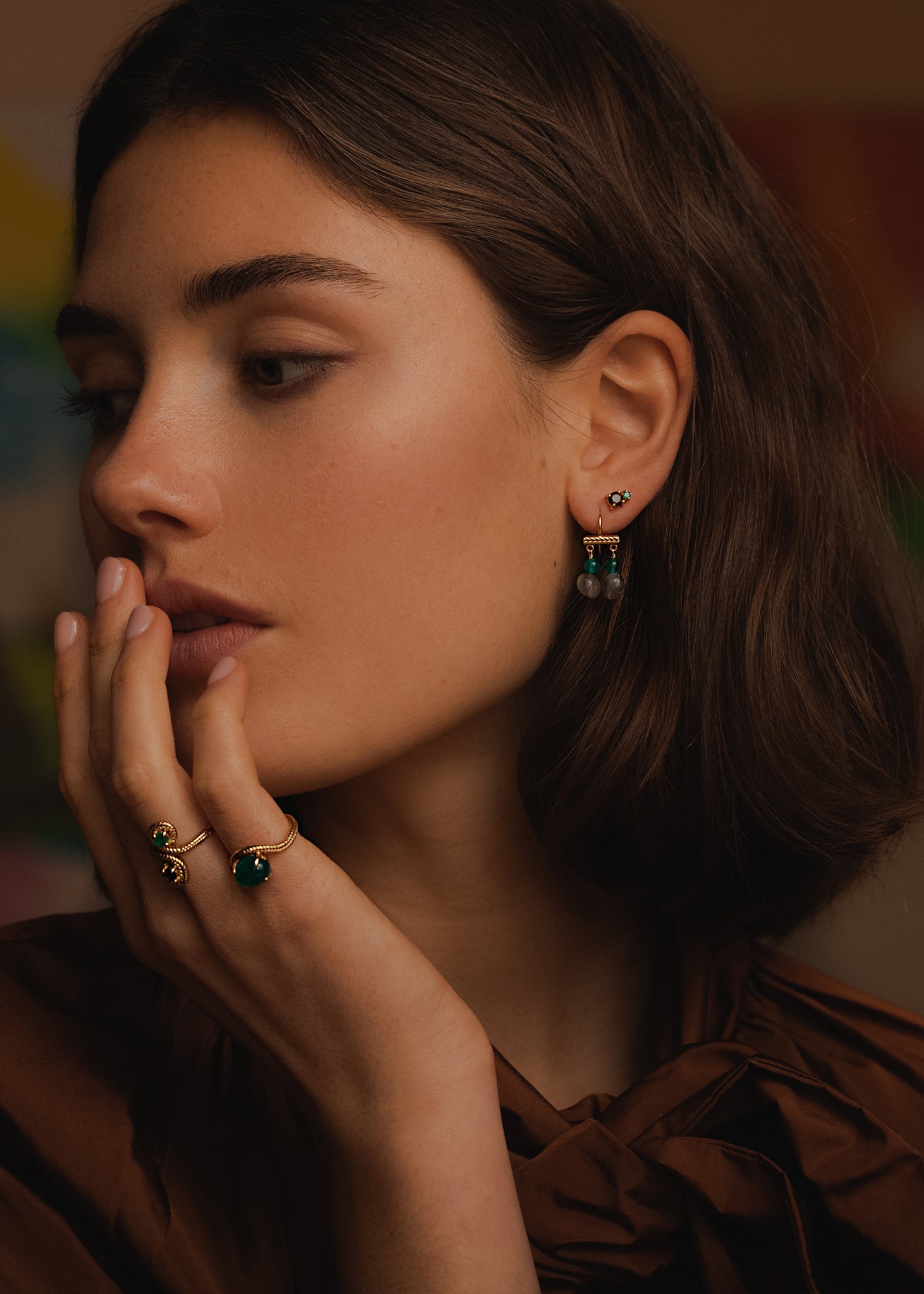 Kvinde med lange guld øreringe fra carré jewellery med grøn agat og labradorit ædelsten