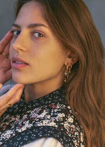 Kvinde med lange hængeøreringe i guldbelagt sterling sølv fra carré jewellerys hoops og charms, hvor du kan bygge dine egne øreringe 