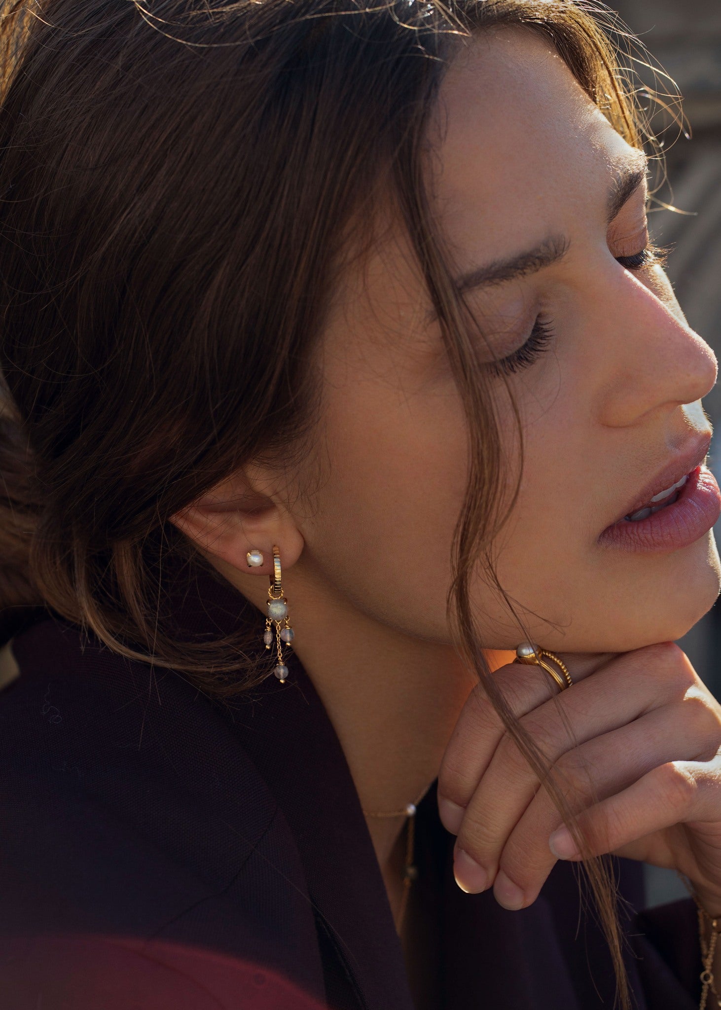 Kvinde med lange hængeøreringe i guld med hoop ørering fra carré jewellery med labradorit ædelsten