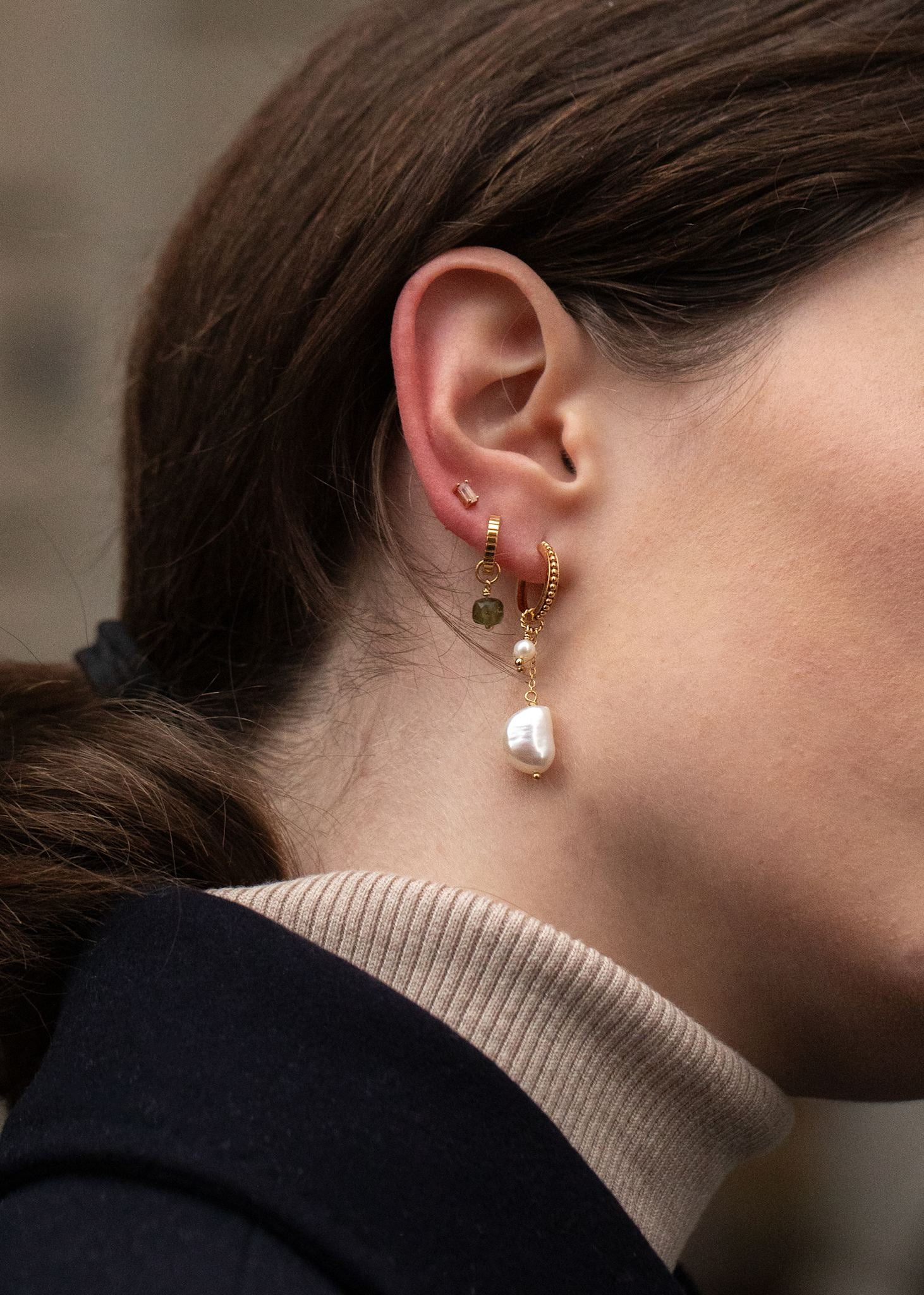 Kvinde med hoops og charms fra carré jewellery med ferskvandsperler og grønne sten, design dine egne øreringe hos Carré Jewellery 
