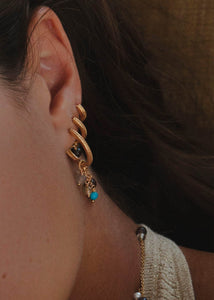Kvinde med lange hængeøreringe i guld med blandede ædelsten fra carré Jewellery