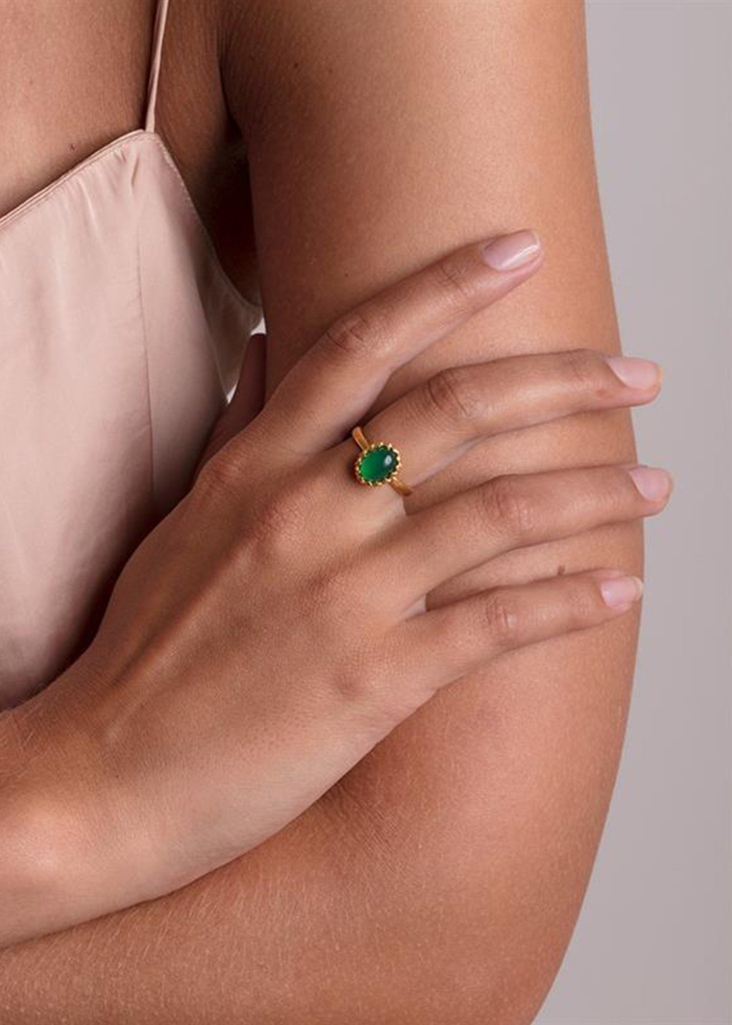 Kvindehånd med lana ring fra carré jewellery i guldbelagt sølv med en grøn agat ædelsten i blondekant 