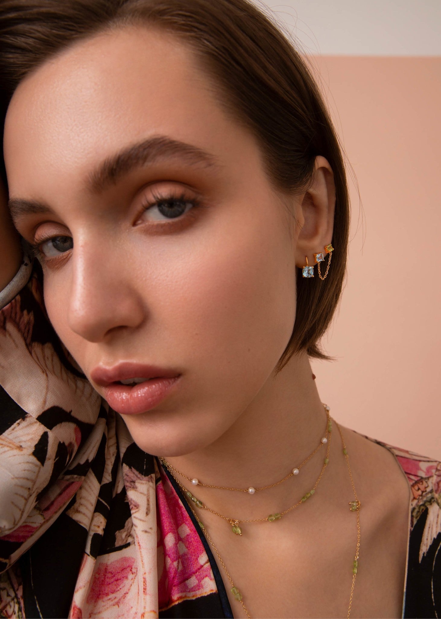 Ung kvinde med guldbelagte smykker fra carré jewellery med blå topas og grønne peridot ædelsten, perfekt gave til hende med fødselsdag i august og november