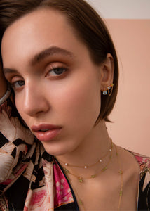 Ung kvinde med guldbelagte smykker fra carré jewellery med blå topas og grønne peridot ædelsten, perfekt gave til hende med fødselsdag i august og november