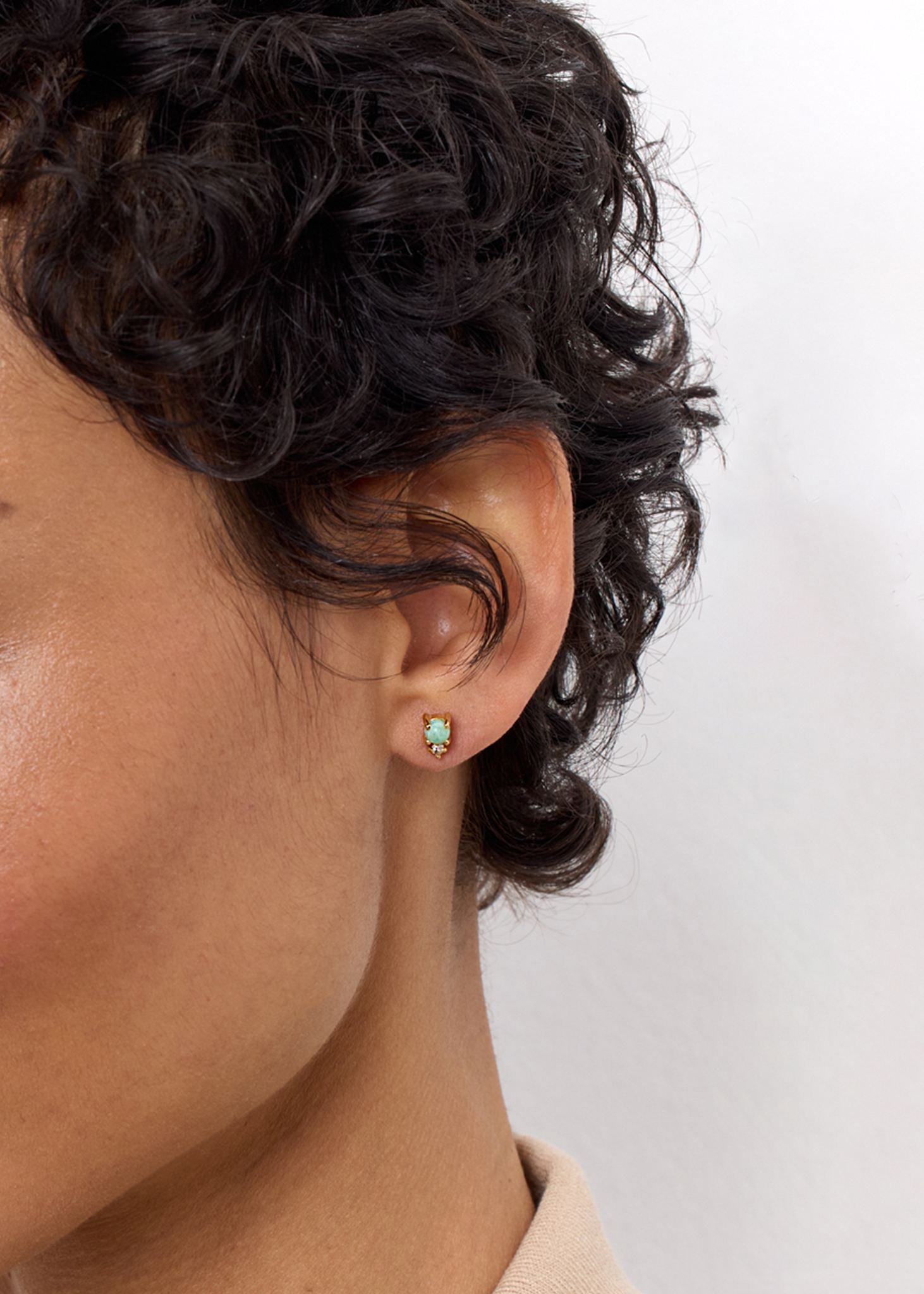 Ung kvinde med små ørestikker i guldbelagt sølv med amazonit og hvid topas ædelsten fra carré jewellery 