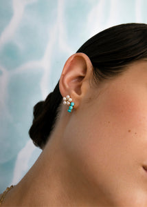 Kvinde med sommersmykker fra carré Jewellery med decembers fødselssten, Turkis og blomster øreringe med hvide ferskvandsperler