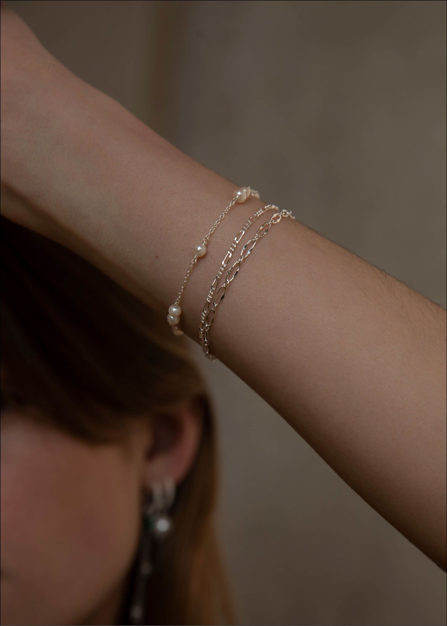Kvinde med vandfaste armbånd i sterling sølv fra carré jewellery med figaro kæder til mænd og kvinder
