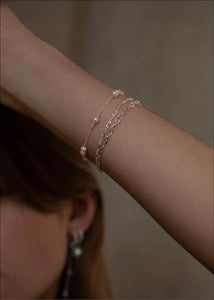 Kvinde med vandfaste armbånd i sterling sølv fra carré jewellery med figaro kæder til mænd og kvinder