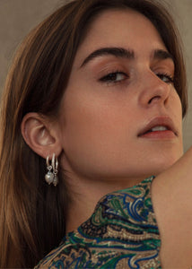 Kvinde med hoops og charms i sterling sølv fra carré jewellery med hvide ferskvandsperler og blå topas ædelsten til ham og hende 