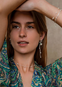 Kvinde med hoops og charms fra carré jewellery med ferskvandsperler i sterling sølv 