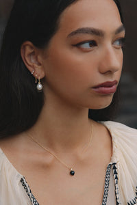 Kvinde med sort hjertevedhæng til halskæder i ægte guld med en diamant og en hjerteformet sort agat ædelsten fra carré jewellery