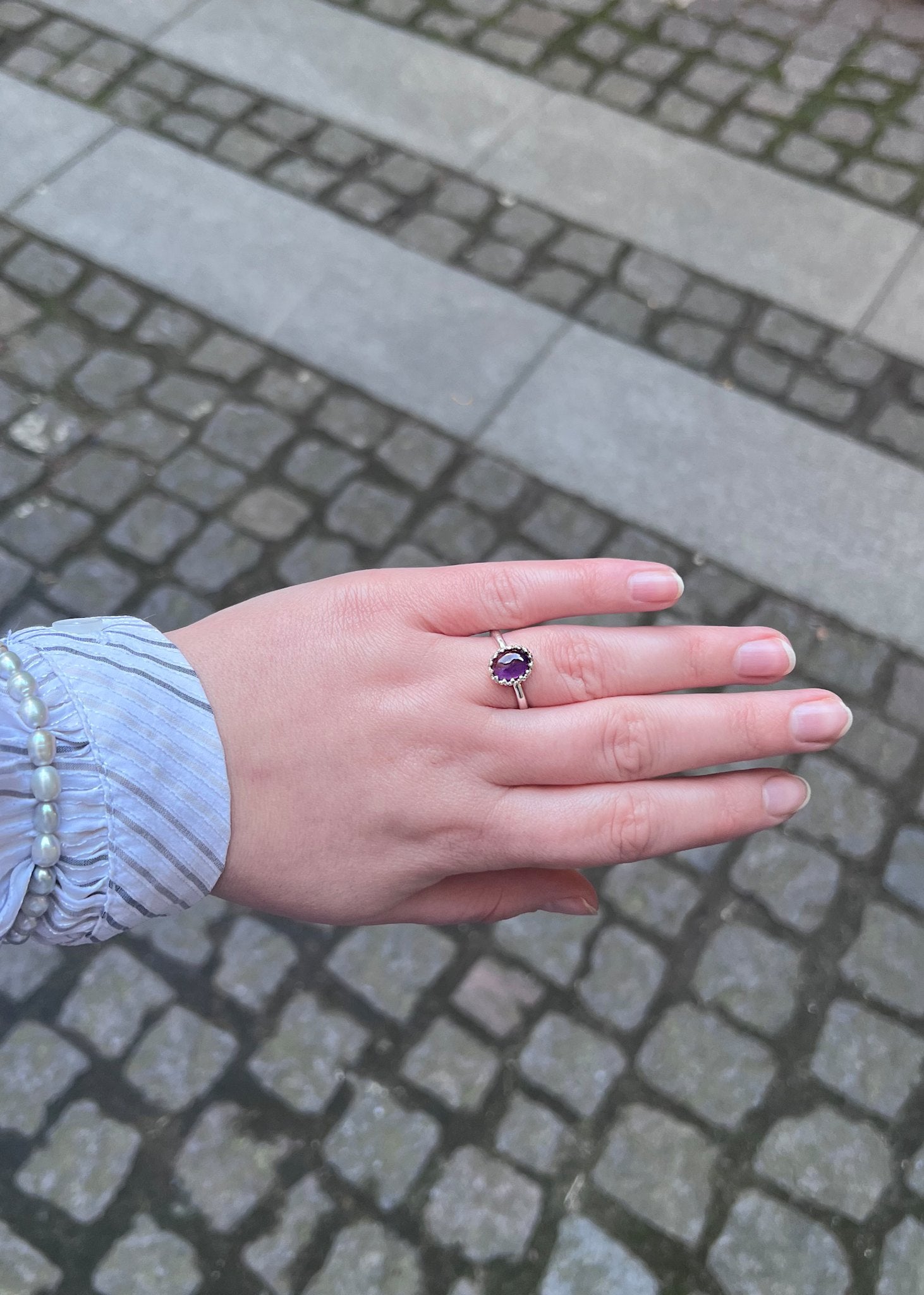 kvindehånd med sterling sølv lana ring med en ametyst ædelsten i blondefatninger
