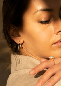 Kvinde med 10-karat guld hoop øreringe fra carré jewellery med lyserøde turmalin ædelsten