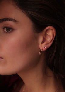 Kvinde med månesten smykker fra Carré jewellery. Hjerteformet ørering i ægte guld med Månesten og en ørestik med pink turmalin