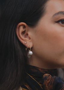 Kvinde med øreringe i ægte guld fra carré jewellery med ferskvandsperler og turmalin
