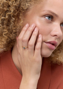 Kvinde med ring i ægte guld fra carré jewellery med london blå topas ædelsten til hende og ham 
