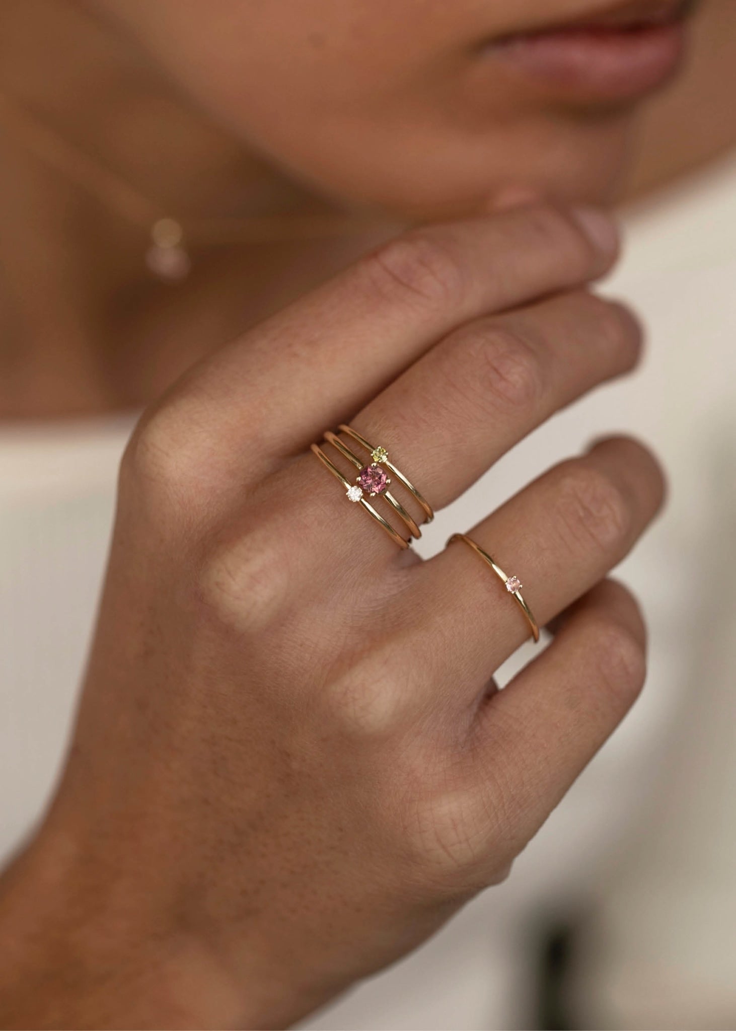 Kvinde med ringe fra carré jewellery i ægte guld med lyserøde og grønne turmalin ædelsten