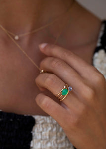 Kvinde med ringe i ægte 10 karat guld med grønne sten 