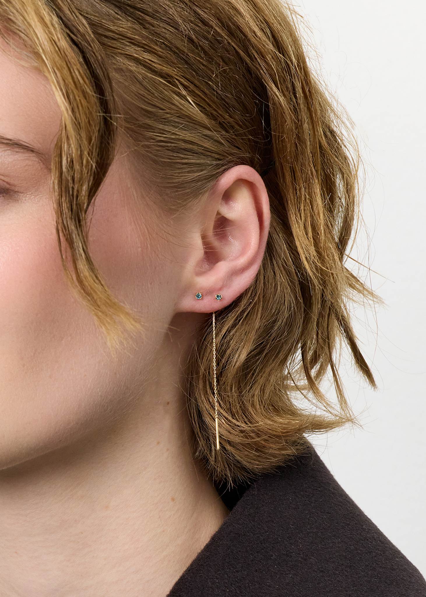 Ung kvinde med lang kædeørestik i 10k guld med novembers fødselssten, london blå topas ædelsten