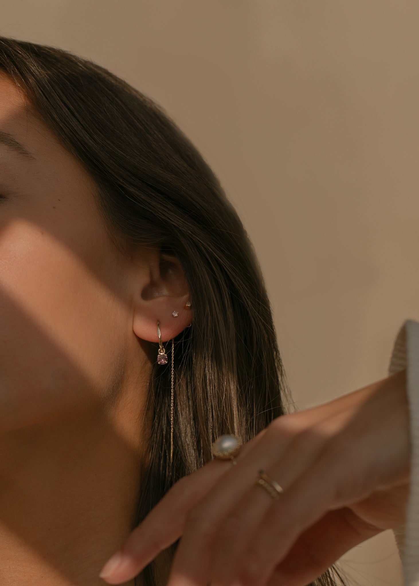 Ung kvinde med ægte guld smykker fra carré jewellery med lyserøde turmalin ædelsten på en threader ørering