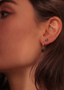 Kvinde med stella hoops og charms fra carré jewellery med london blå topas ædelsten i ægte guld 