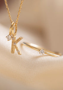 10-karat guldsmykker fra carré med diamanter. Et bogstavsvedhæng med diamant med bogstavet K, et vedhæng til halskæder med diamant, og en forlovelsesring med diamant