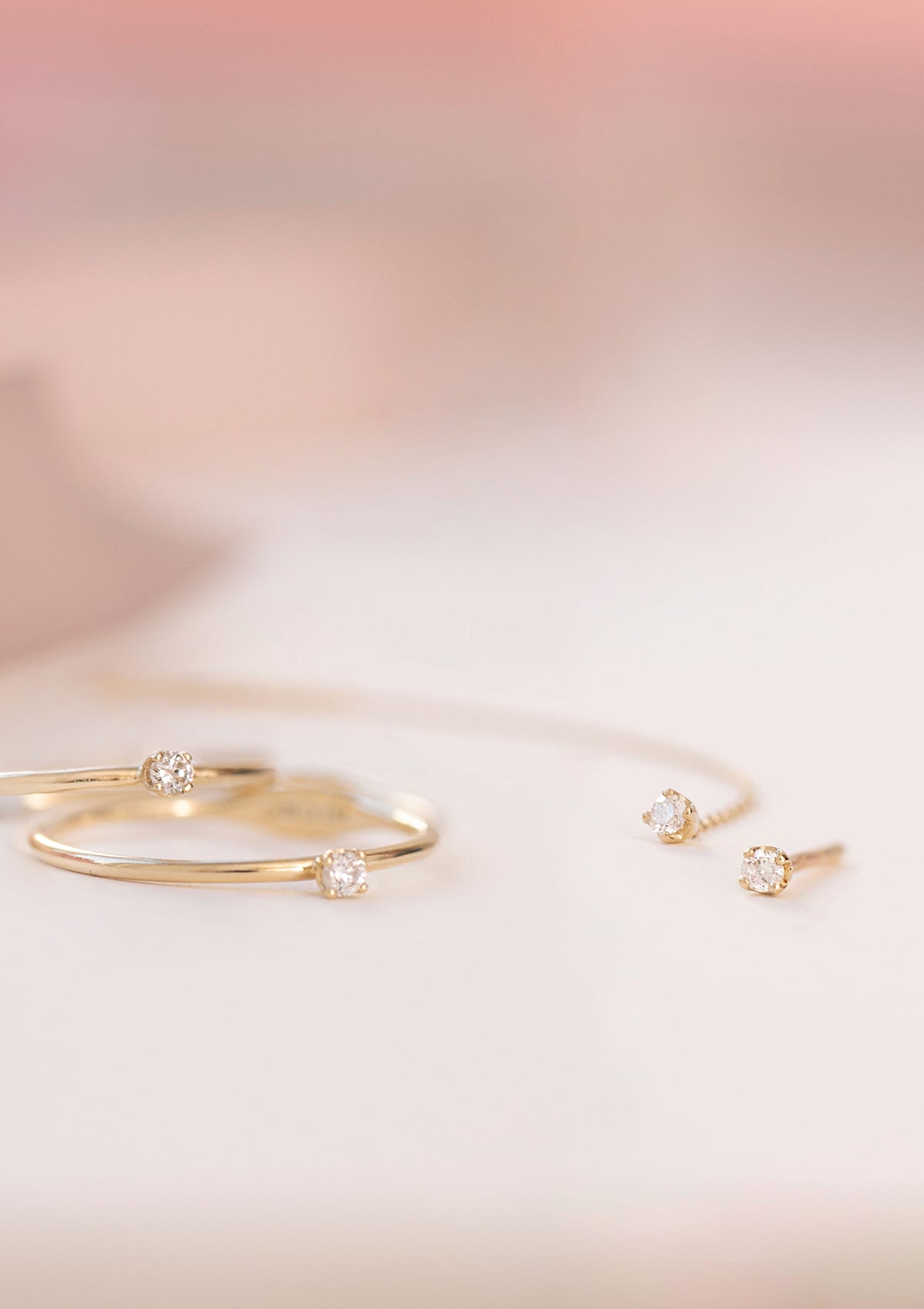 10-Karat smykker fra carré. To ringe med diamanter og en lang ørestik med kæde med diamant og en lille ørestik med en diamant.