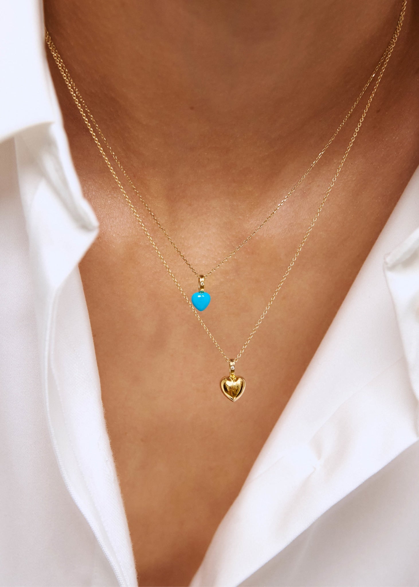 To hjertevedhæng i ægte guld fra carré jewellery med en hjerteformet blå turkis ædelsten og et guld hjerte vedhæng med en diamant