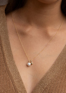 Kvinde med to guld vedhæng til halskæder fra carré jewellery, begge med diamanter og perler