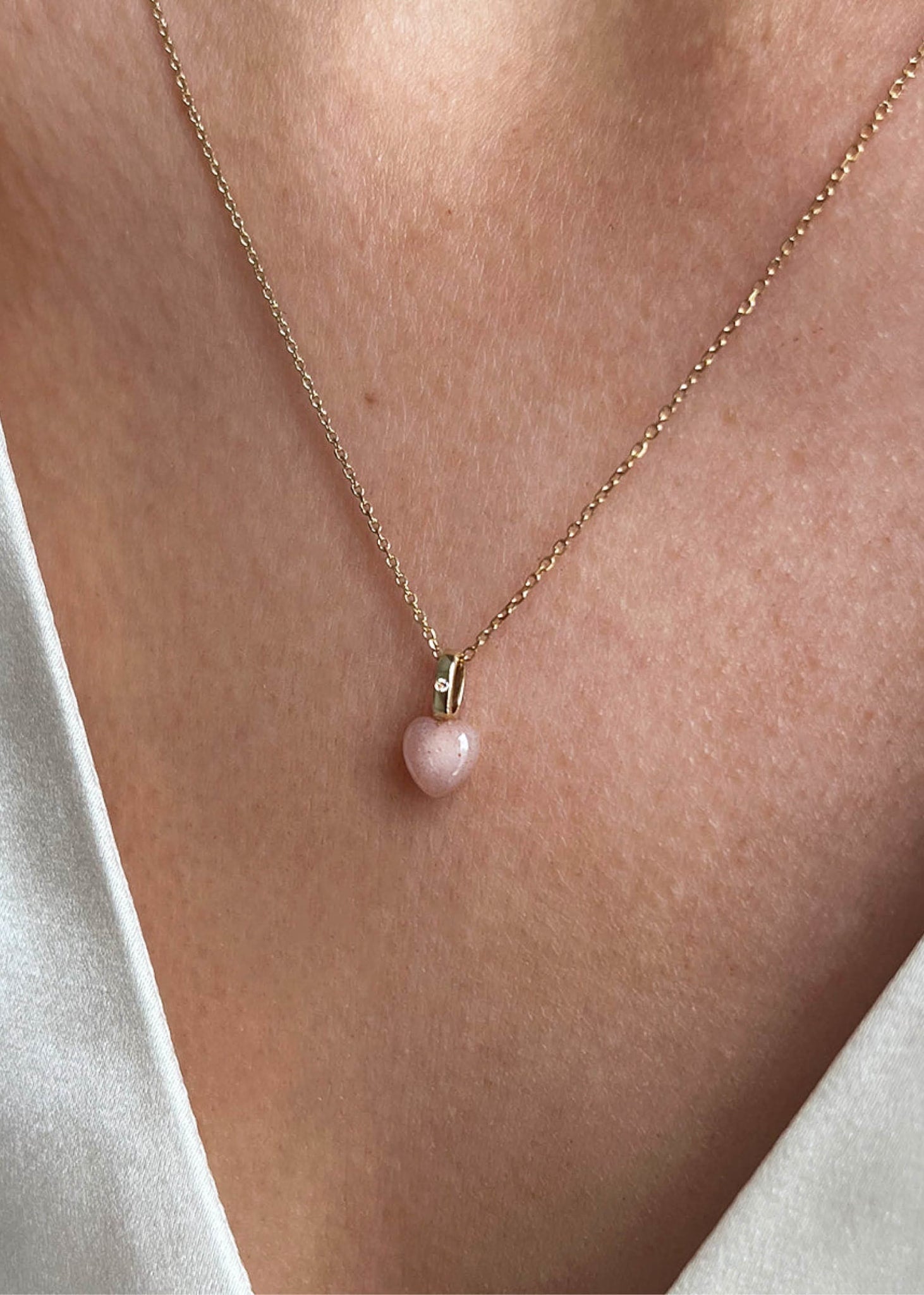 Kvinde med hjertehalskæde fra carré jewellery med en sandfarvet månesten ædelsten og en diamant